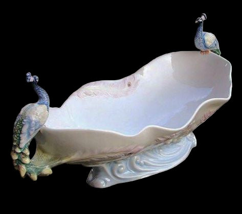 Decorative ceramic dish with peacock designs on a white background