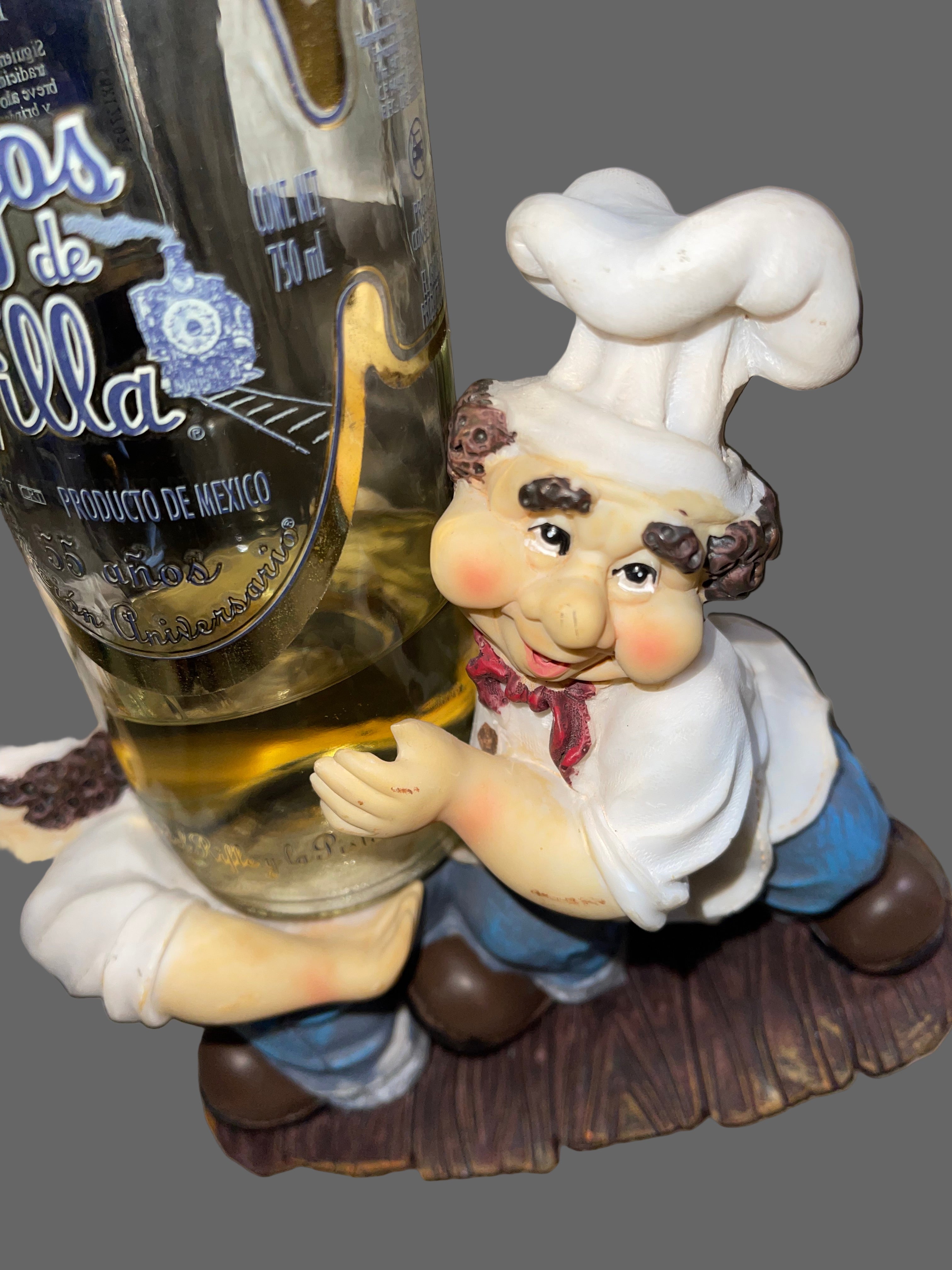 Figurine of a chef on top of a bottle with a label